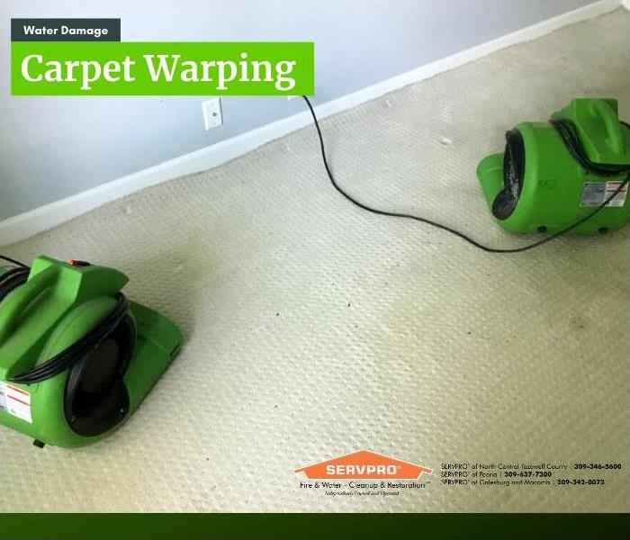 Air movers placed and drying a carpet that had warped from the water damage to it.